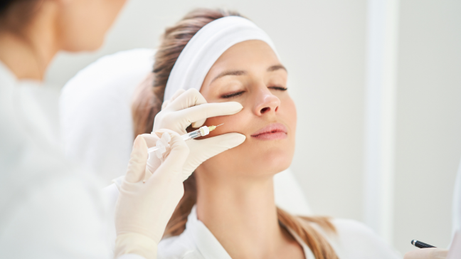 Provider injecting a non-surgical jowl treatment into a woman's face